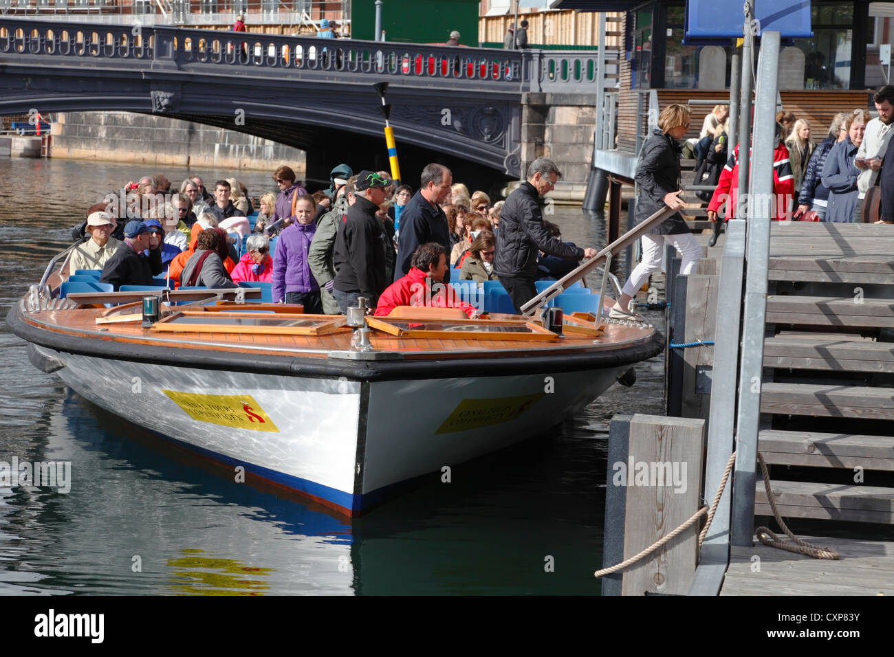 Passagiere aussteigen / einsteigen einen Kanal Kreuzfahrt Boot bei Højbro Plads (Hoejbro Platz) in Kopenhagen, Dänemark. Hoejbro Brücke. Stockfoto