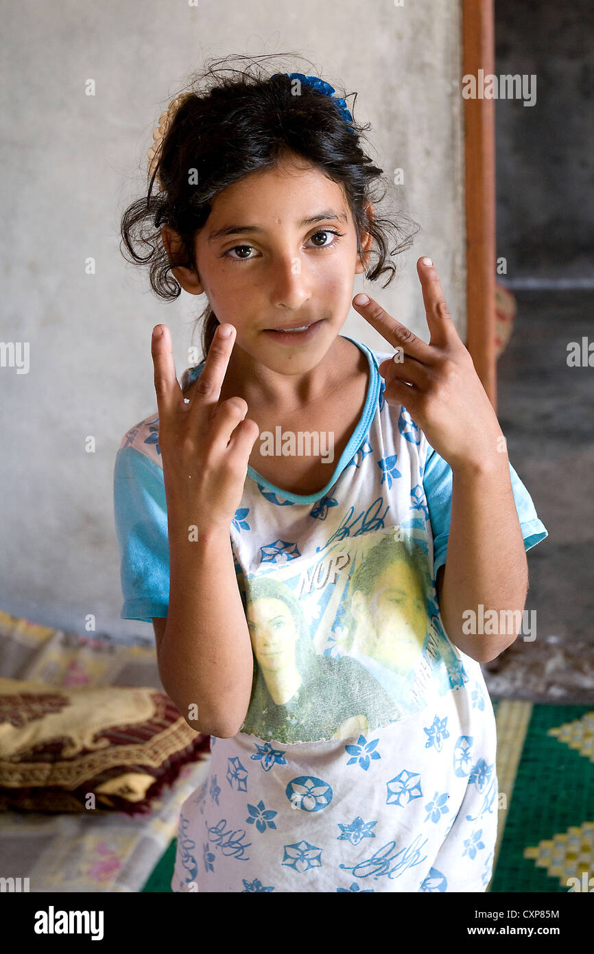 Ein syrisches Flüchtlingskind hält die Finger hoch im Siegeszeichen, in der Region Wadi Khaled im Nordlibanon, nahe der Grenze zu Syrien. Stockfoto