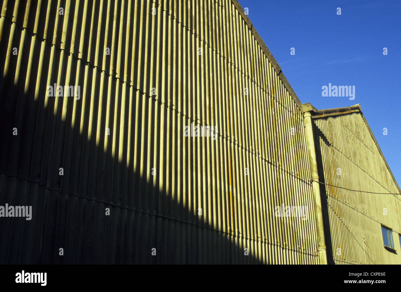 Detail Seite des Werk oder Lager mit Wellen von Wellblech Wände Sidelit unter blauem Himmel Stockfoto