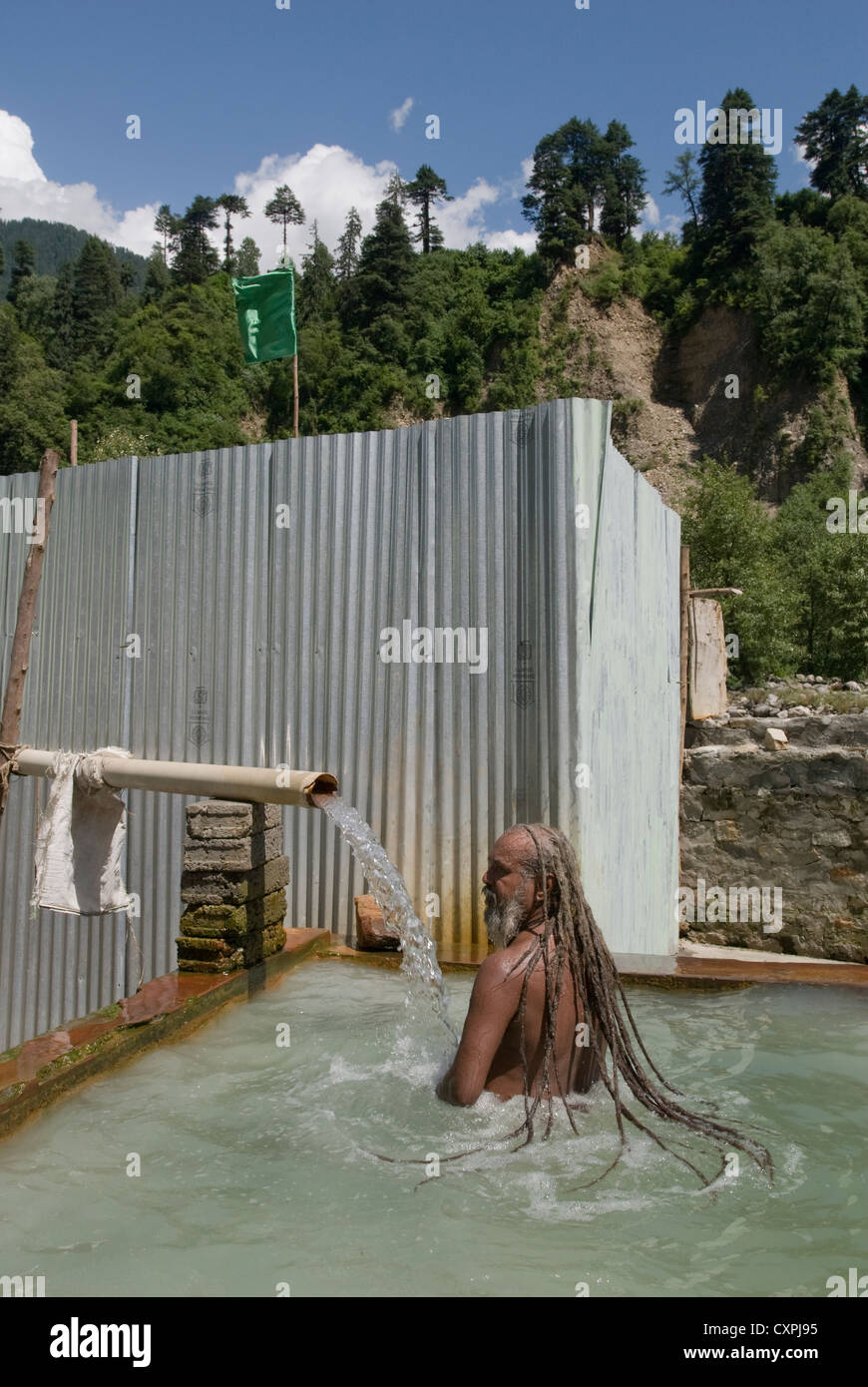 Ein Hindu Sadhu (Heiliger) nimmt ein Bad in einer heißen Quelle in der Nähe von Manali, Nord-Indien Stockfoto