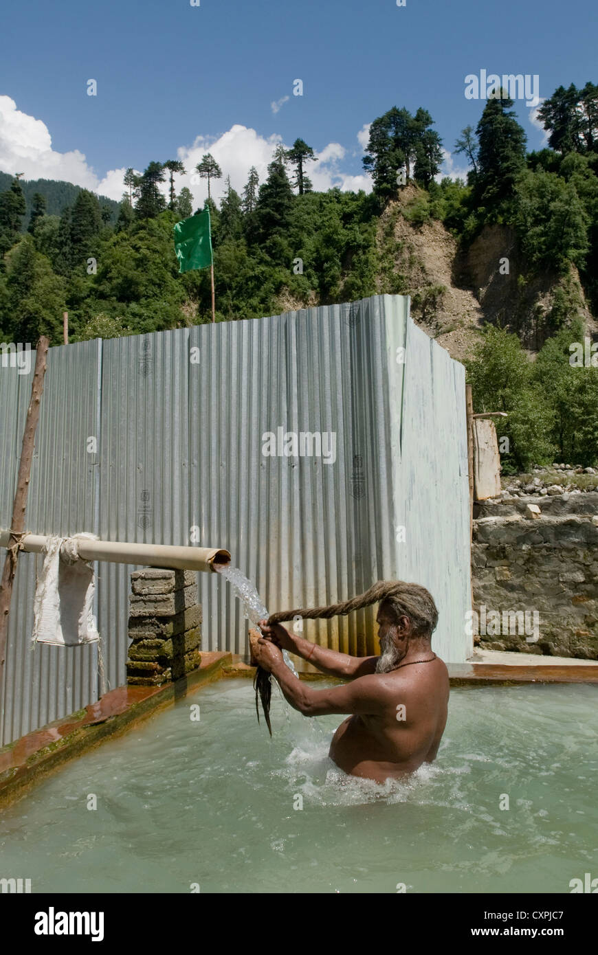 Ein Hindu Sadhu (Heiliger) nimmt ein Bad in einer heißen Quelle in der Nähe von Manali, Nord-Indien Stockfoto