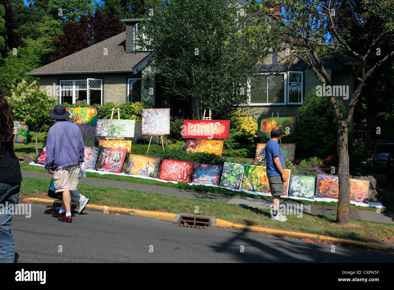 Man anhalten, um vor einem Haus an einem externen Sommer-Kunstmesse und Verkauf ist eine jährliche Veranstaltung ausgestellten Gemälde betrachten Stockfoto