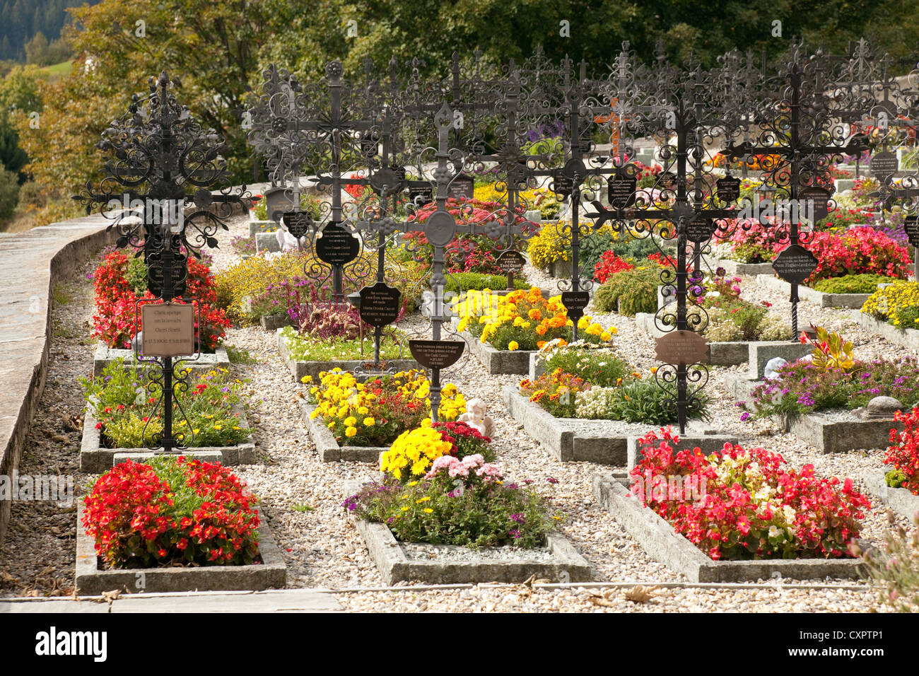 Bunte Blumen auf Gräbern in einem Schweizer Friedhof, St. Remigius, Falera,  Graubünden, Schweiz Stockfotografie - Alamy