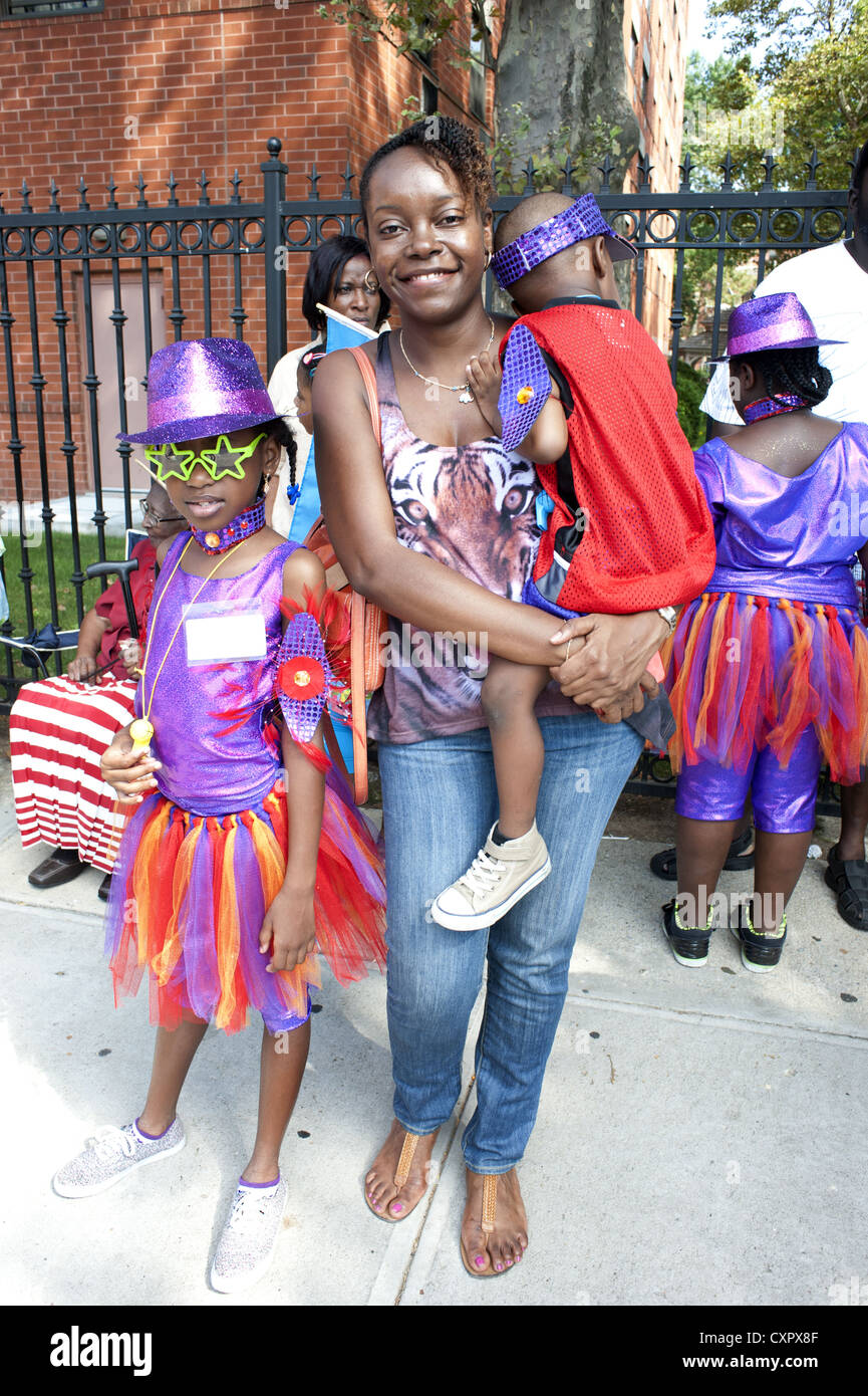 USA: Brooklyn, NY. Mutter und ihre beiden kostümierte Kinder warten, um in der Karibik Kiddies Day Parade, März 2012. Stockfoto