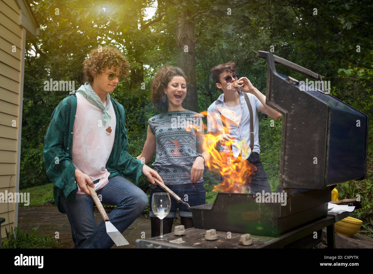 Junge Erwachsene Freunde genießen einen Hinterhof Grill Stockfoto
