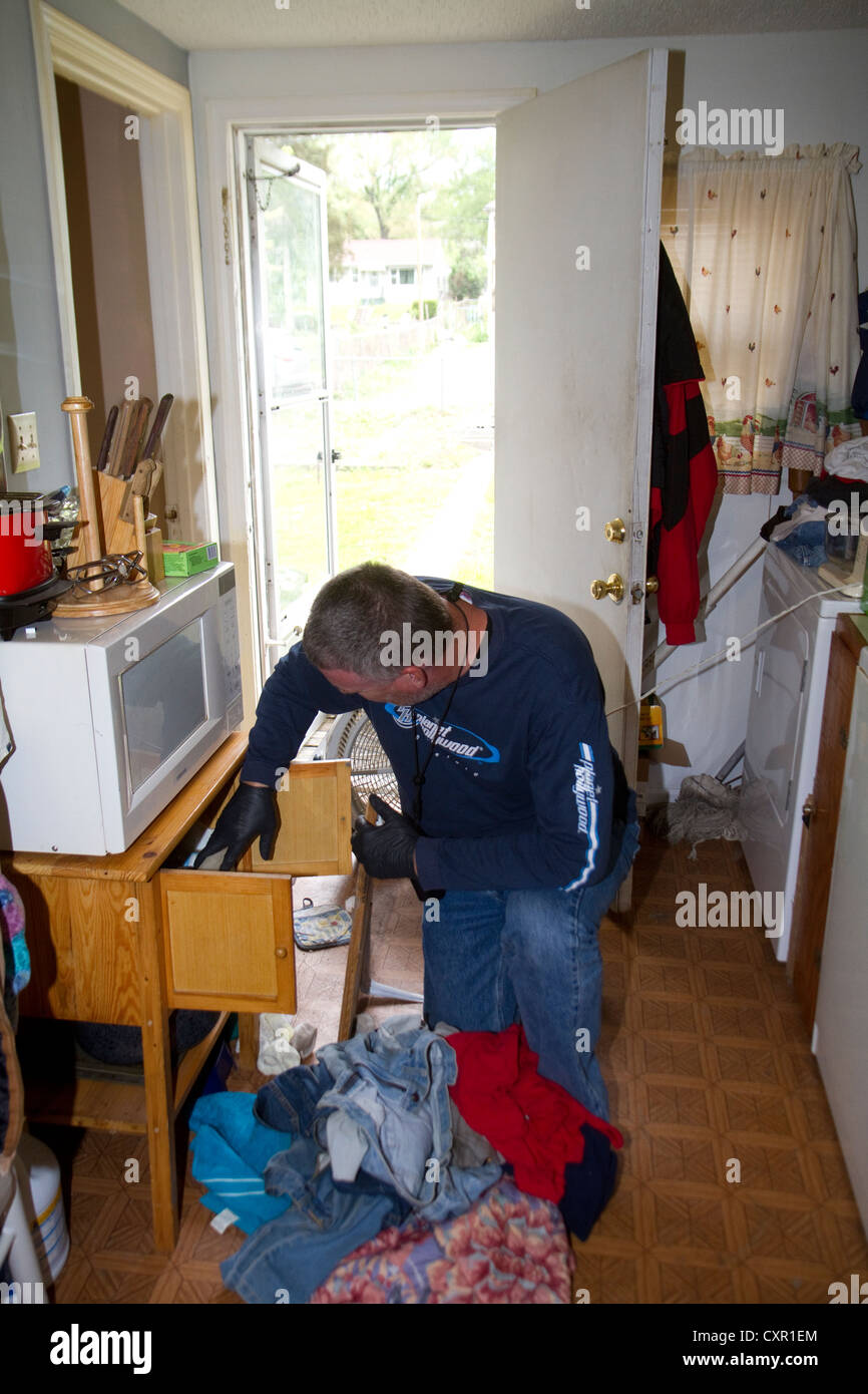 Polizei-Sergeant auf der Suche nach illegalen Drogen während der Hausdurchsuchung... Metro-Meth-Einheit. Stockfoto