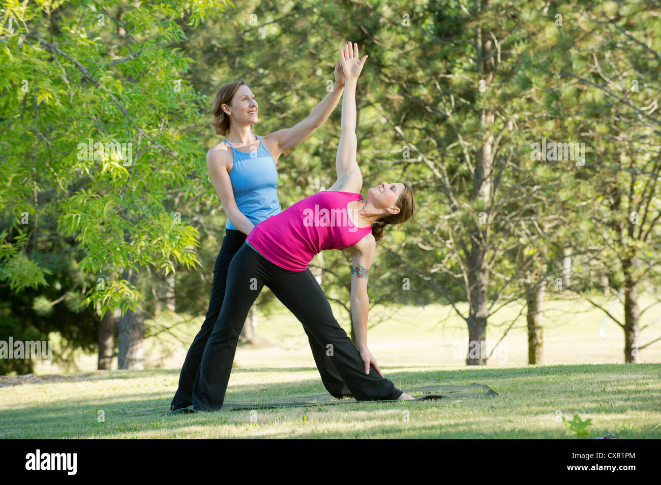 Yoga-Lehrer und Schüler im park Stockfoto