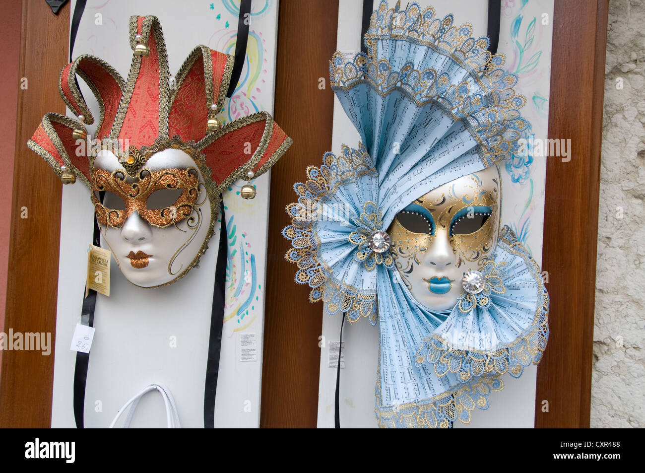 Eine Ausstellung von Masquerade-Kugelmasken und venezianischen Masken, die in der Stadt Bardolino, einem Ferienort/Fischerhafen in der Rotweinbauregion am Meer, zum Verkauf angeboten werden Stockfoto
