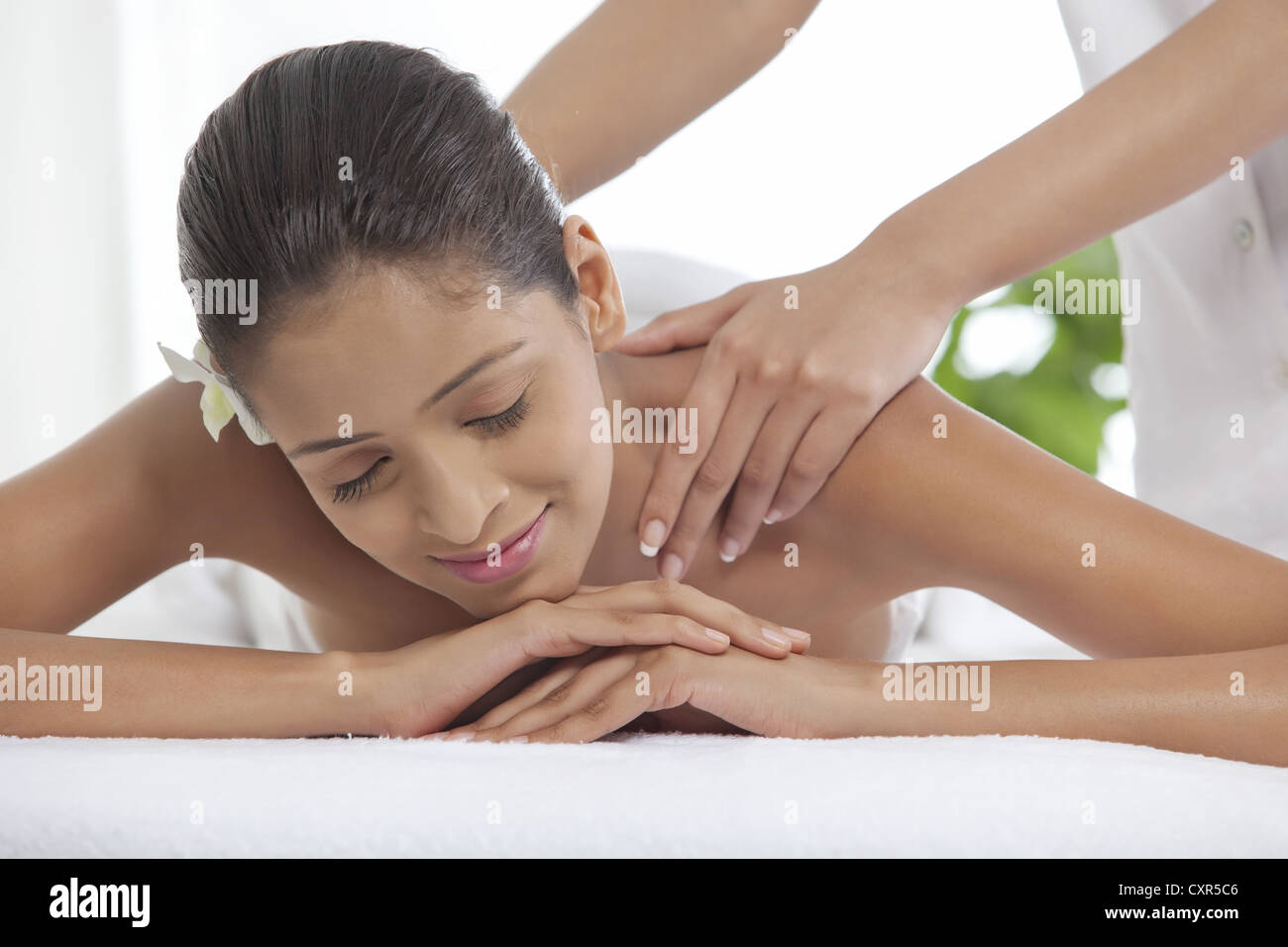 Junge Frau, die immer einer Rückenmassage im Wellnessbereich Stockfoto