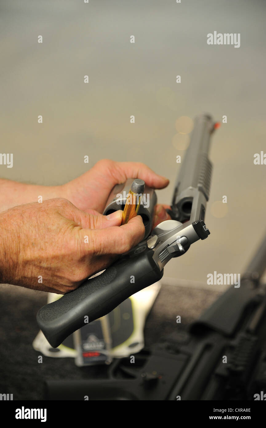 Männlichen Händen mit Smith und Wesson 500 Magnum und Kugel auf firing Range, Colorado, USA Stockfoto