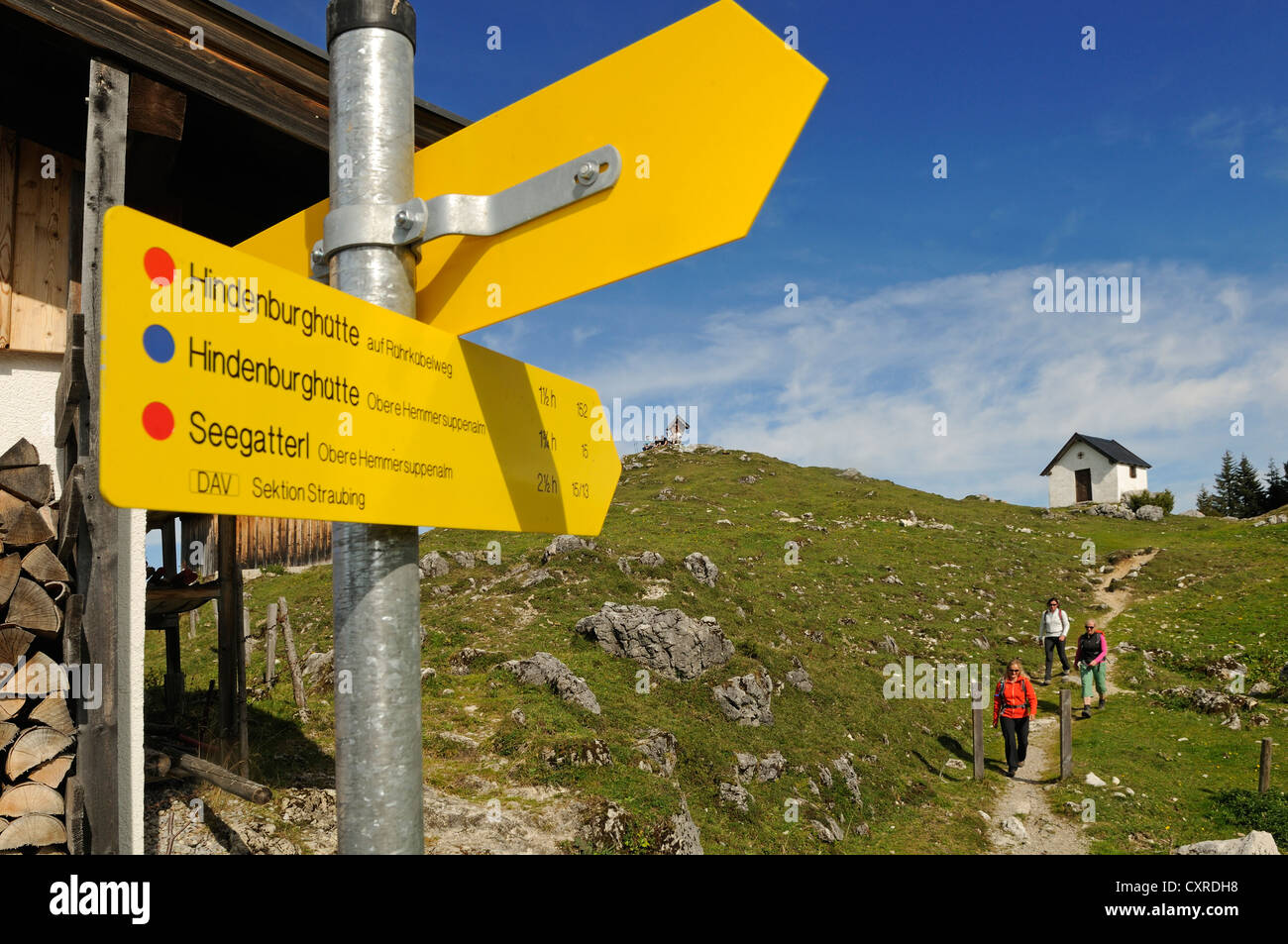 Wegweiser, weibliche Wanderer zu Fuß auf der Eggenalm Alp, Grenzgebiet zwischen Waidring, Tirol, Österreich, und Reit Im Winkl, Chiemgau Stockfoto