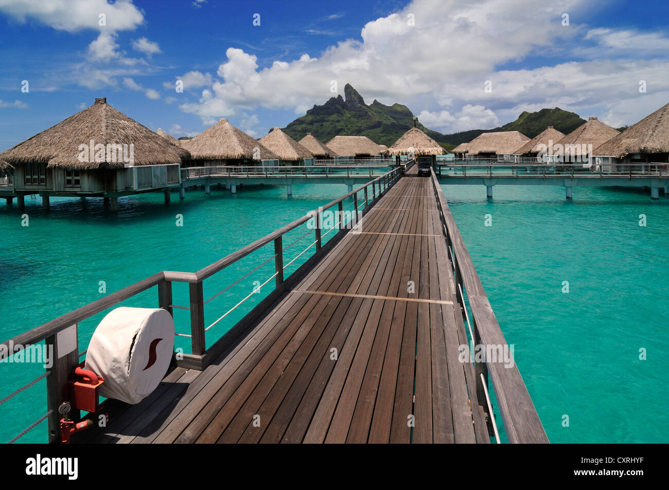 Promenade, Hütten auf Stelzen, Mt Otemanu hinten aus St. Regis Bora Bora Resort, Bora Bora, Leeward-Inseln, Gesellschaftsinseln Stockfoto