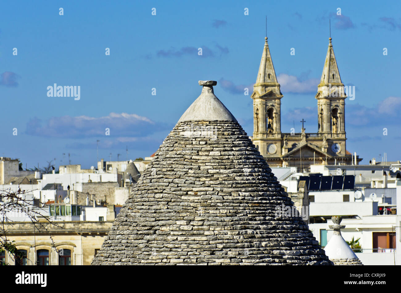 Dach ein Trullo, rund um Haus, mit Blick auf die Basilica Minore dei Santi Medici, im Dorf Alberobello, Apulien, Italien Stockfoto