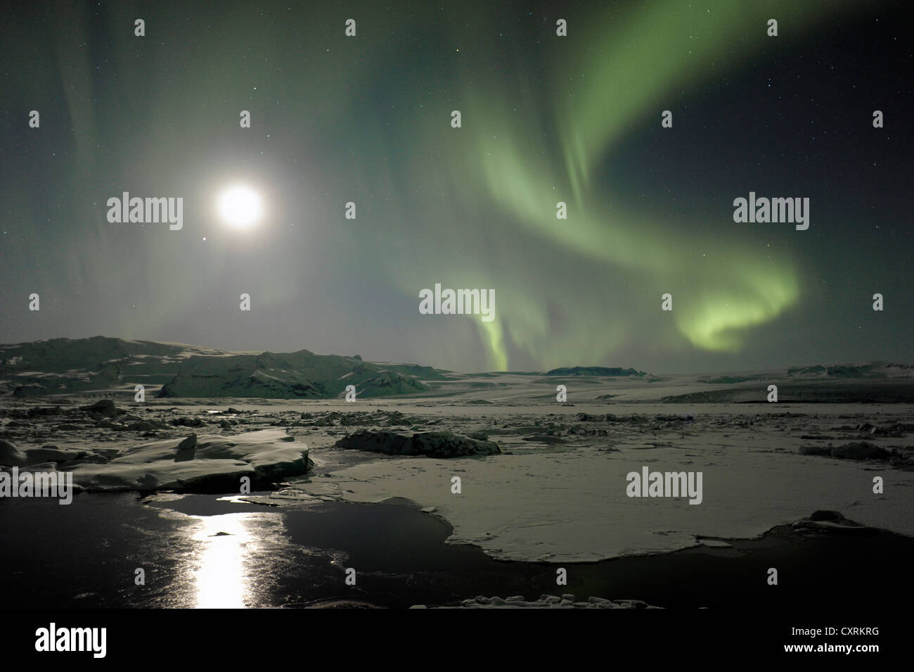 Grüne Nordlicht, Aurora Borealis, mit dem Mond über die Gletscherlagune Joekulsárlón und die Brei amerkurjoekull, Stockfoto