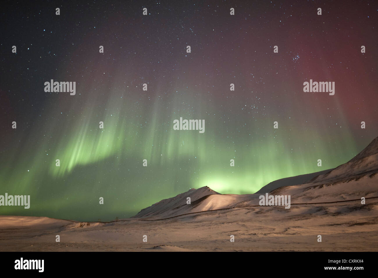 Grünes und rotes Polarlicht, Nordlicht, Aurora Borealis über eine verschneite Landschaft, Landschaft mit beleuchteten Stockfoto