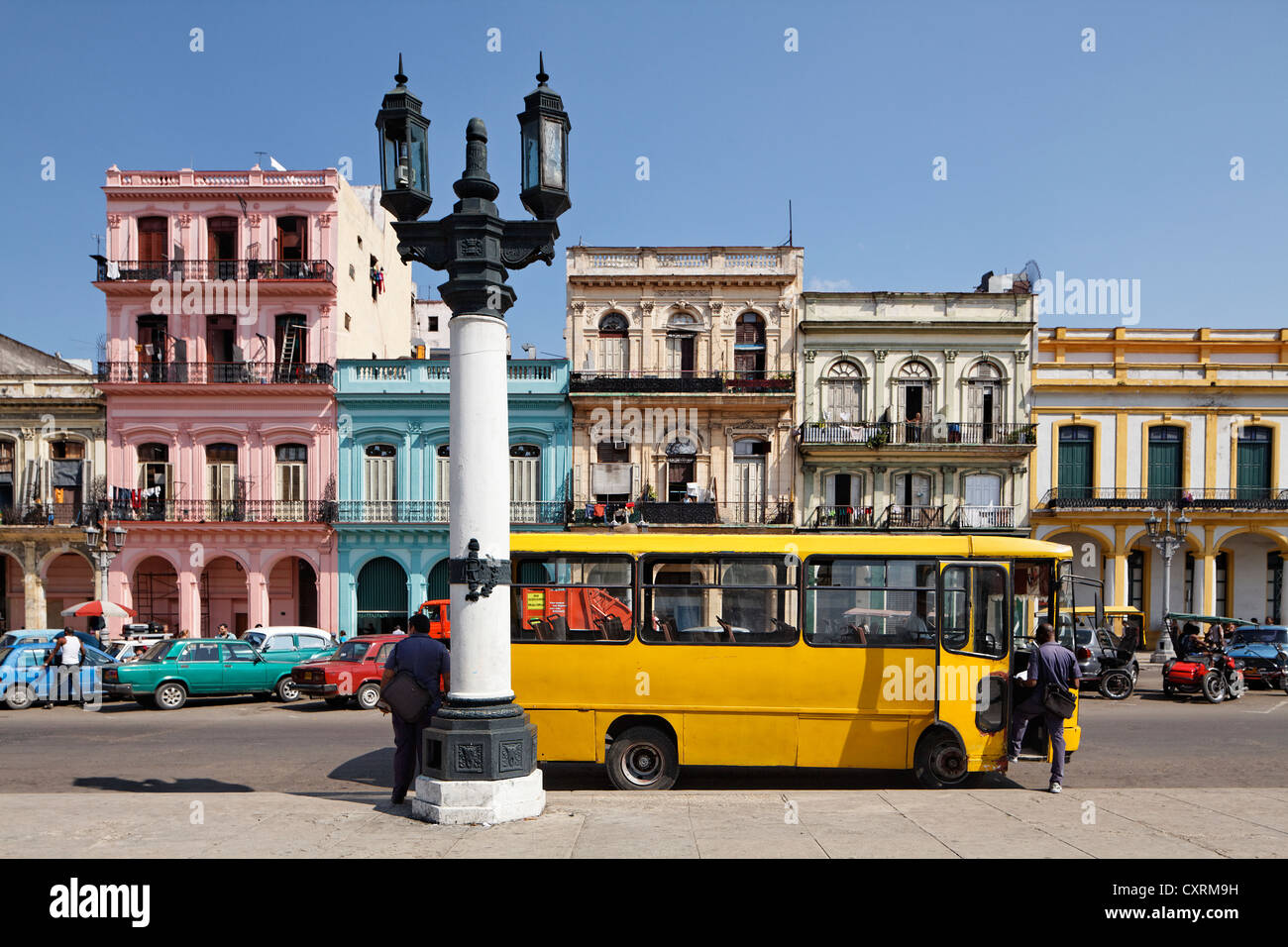 Straße mit Reihe von Häusern, Kandelaber Laterne und einem gelben Bus, Villa San Cristobal De La Habana, Altstadt, La Habana, Havana Stockfoto
