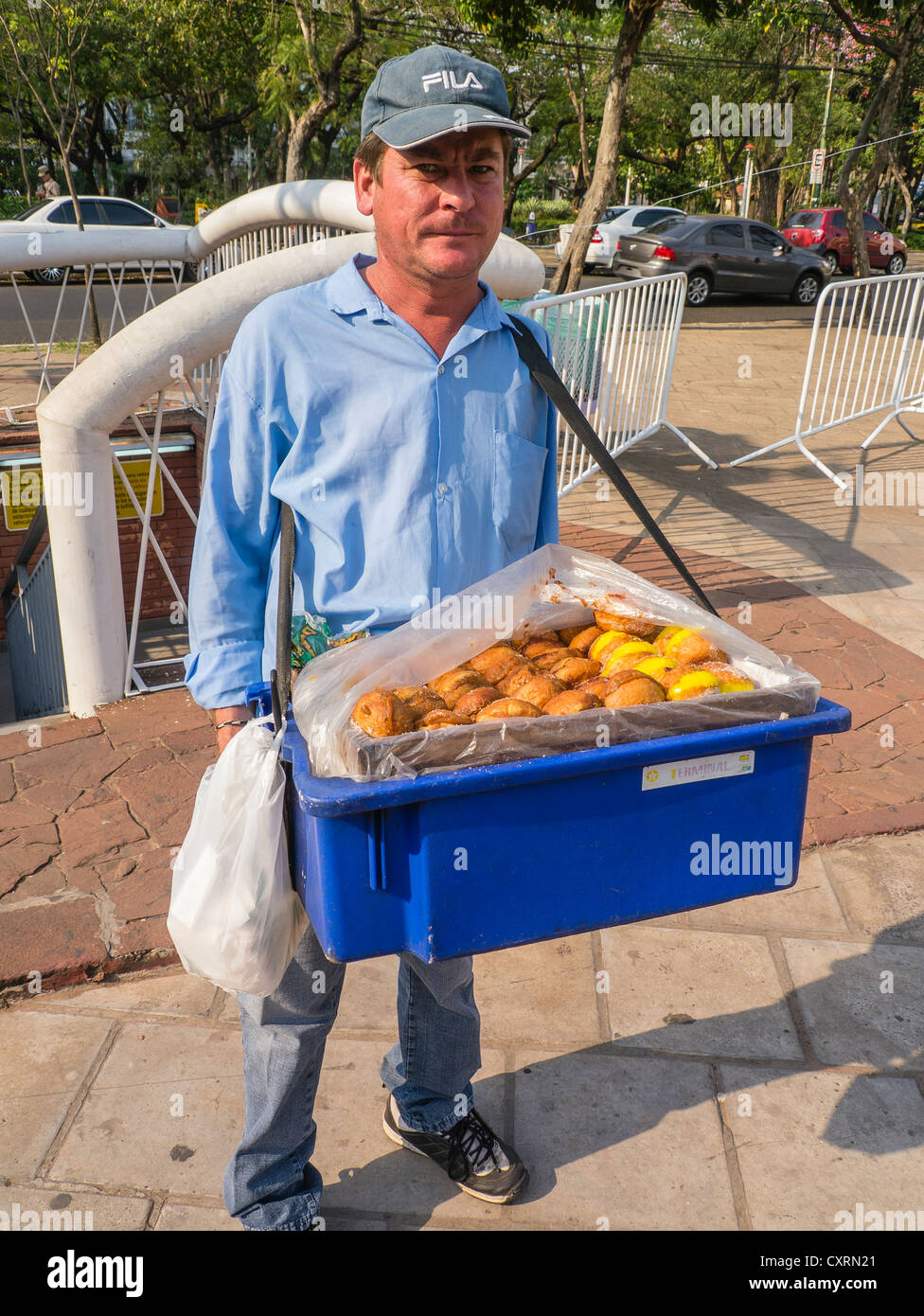 Eine Straße Verkäufer trägt einen Behälter mit "Chipas", die traditionelle paraguayische Käse Brötchen zum Verkauf auf der Straße in Asunción. Stockfoto