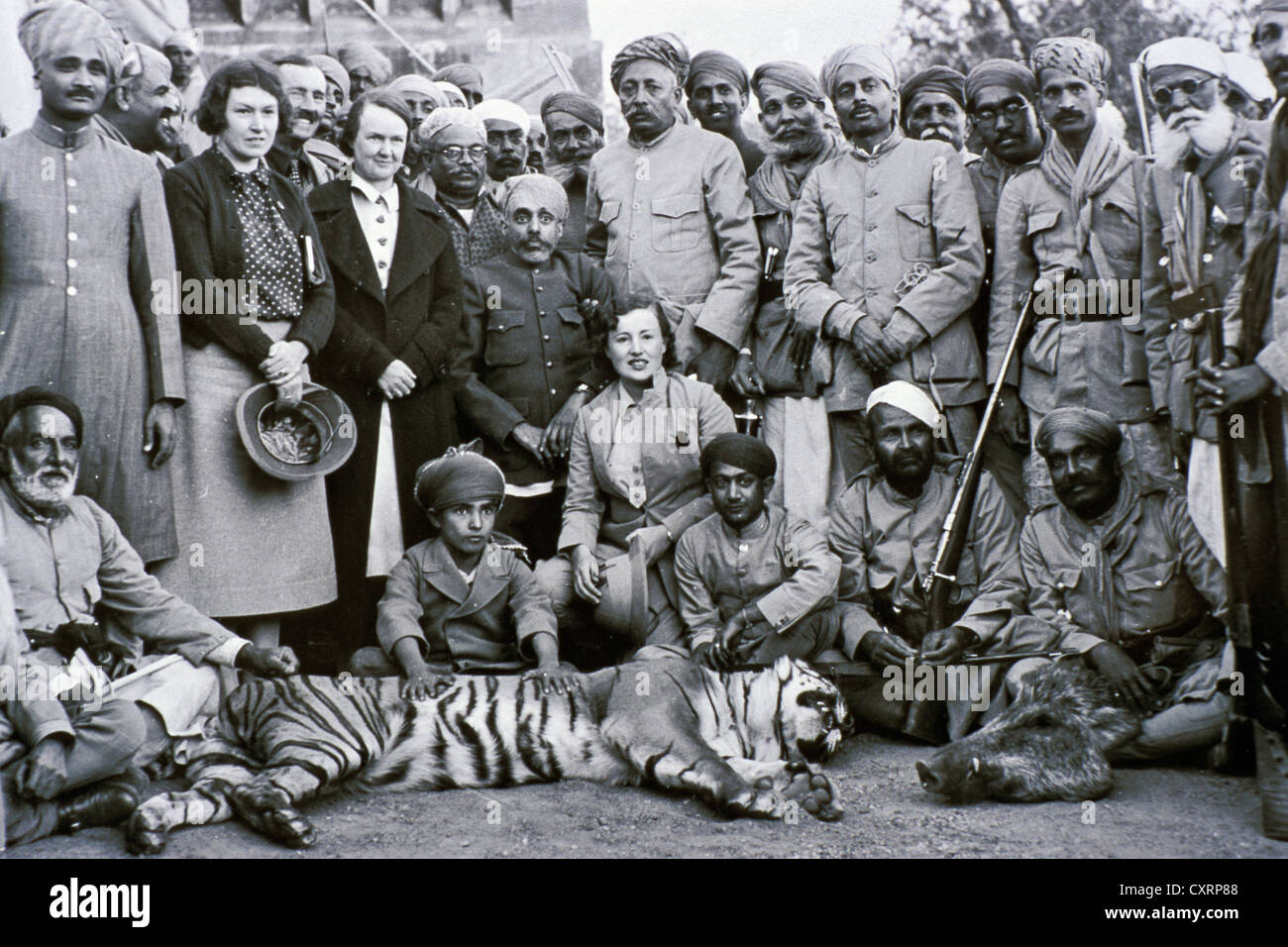 Jagdgesellschaft bestehend aus Briten und Indern, mit Bhupal Singh der Maharana von Udaipur, mit Gejagten tiger Stockfoto