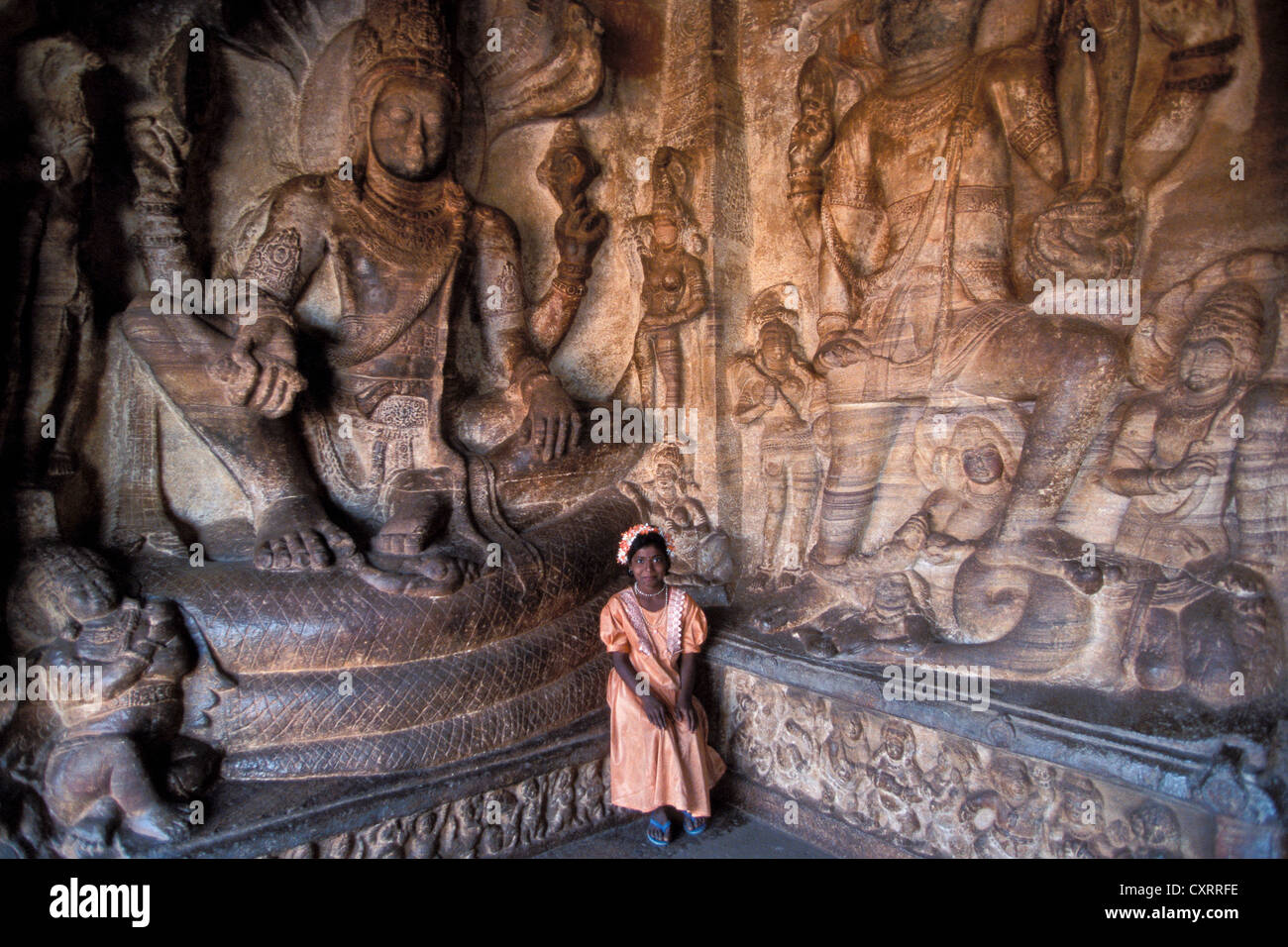 Mädchen vor ein Relief mit Hindu-Götter, Höhlentempel von Badami, Karnataka, Südindien, Indien, Asien Stockfoto