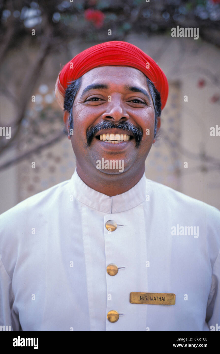 Rajasthani Mann mit einem roten Turban, Lächeln, Porträt, City Palace, Udaipur, Rajasthan, Indien, Asien Stockfoto