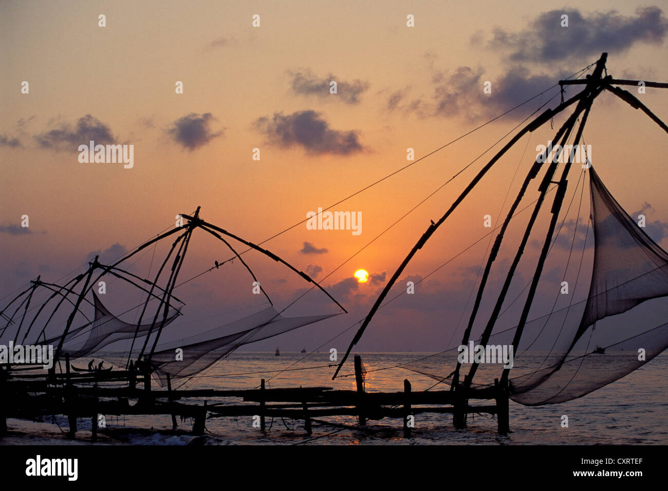 Typische chinesische Fischernetze an der Küste des Arabischen Meeres bei Sonnenuntergang in Fort Kochi, Cochin, Kerala, Südindien, Indien, Asien Stockfoto