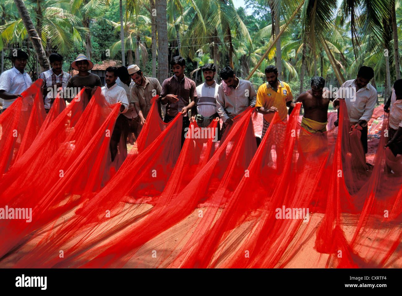 Fischer mit einem roten Fischernetz in der Nähe von Kasargod, Kerala, Malabar-Küste, Süd-Indien, Indien, Asien Stockfoto