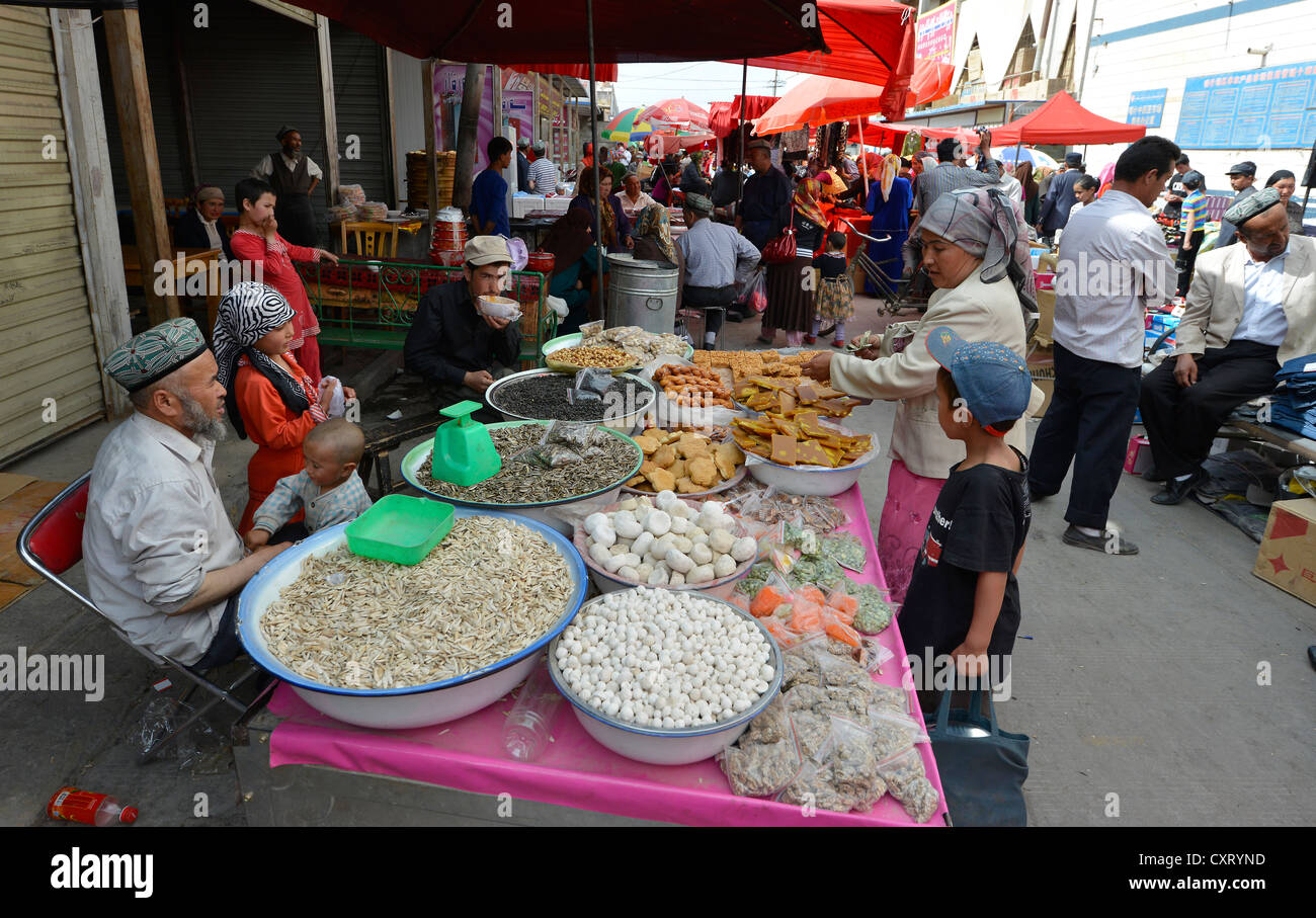Sonntagsmarkt, Markt, Stall ein Uyghur Familie verkaufen Sonnenblumen Samen, getrockneten Früchten und Nüssen, muslimische Basar, Uighur, Kashgar Stockfoto