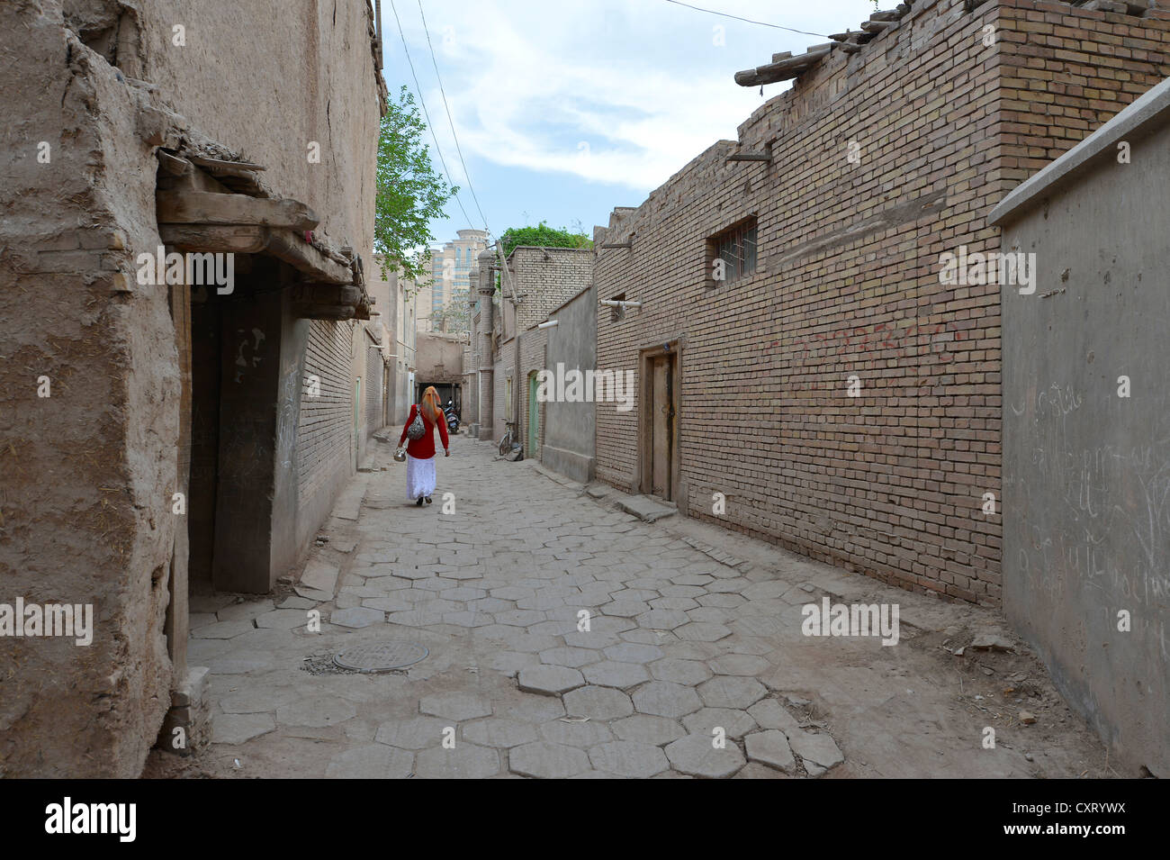 Die muslimische Frau zu Fuß aber eine Gasse in der Altstadt die uigurischen Viertel, alten Adobe Ziegelarchitektur, Seidenstraße, Kashgar Stockfoto