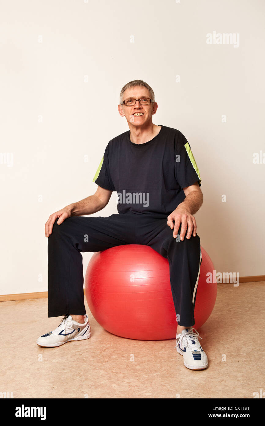 Mann sitzt auf einem Gymnastikball Stockfoto