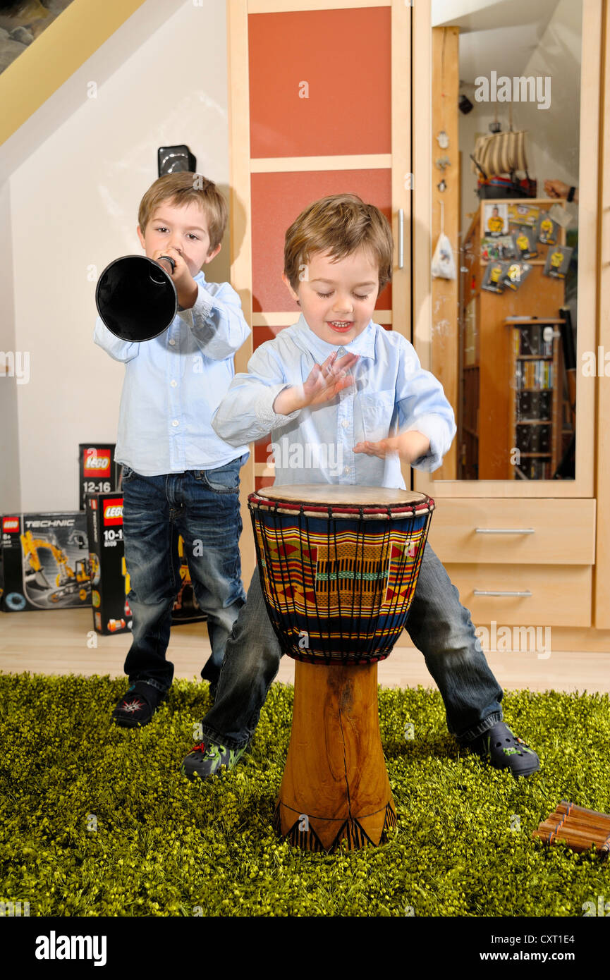 Zwei jungen, 4, Musizieren zusammen mit einer Vuvuzela und eine Trommel Stockfoto