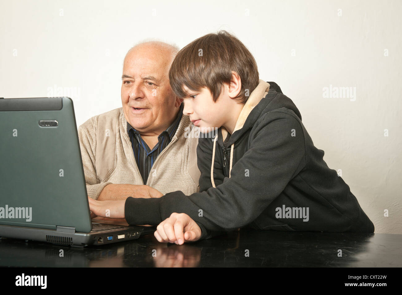 Ein Alter Mann und ein Junge sitzt vor einem laptop Stockfoto