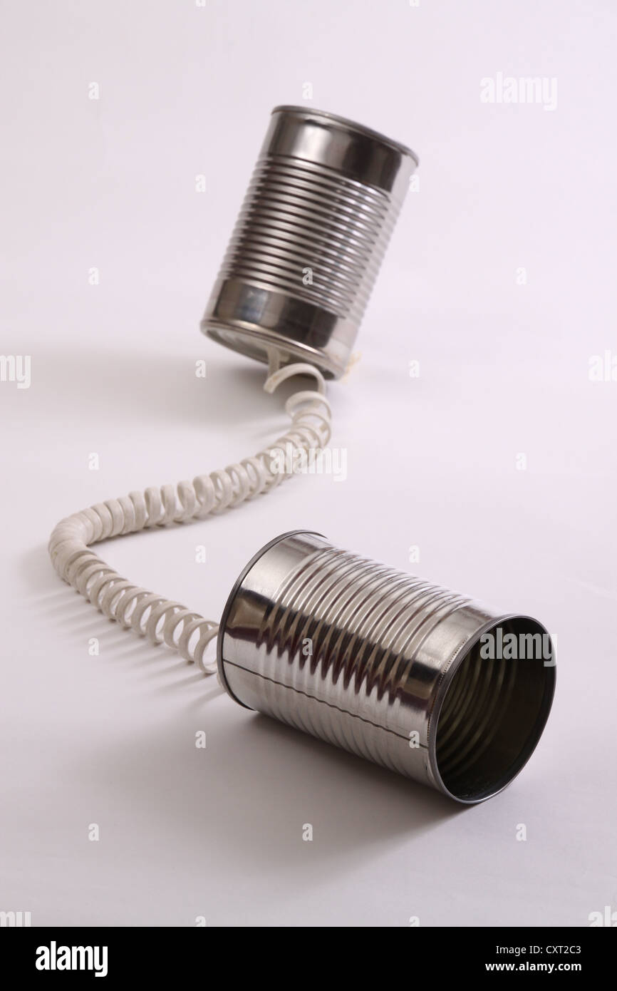 Zwei Blechdosen, verbunden durch ein aufgerollter Telefonkabel, ein frühes Telefon-Konzept darstellt. Stockfoto
