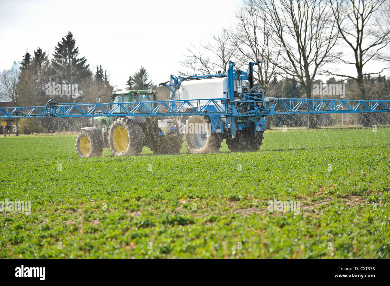 Landwirt in einem Traktor Spritzen Unkrautvernichtungsmittel auf einem Feld Stockfoto
