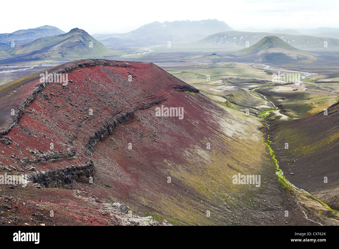 Ein roter Berg, bestehend aus Rhyolith Gesteine und Mineralien mit einem Eisengehalt, umgeben von Grün, mit Moos bedeckten Bergen Stockfoto