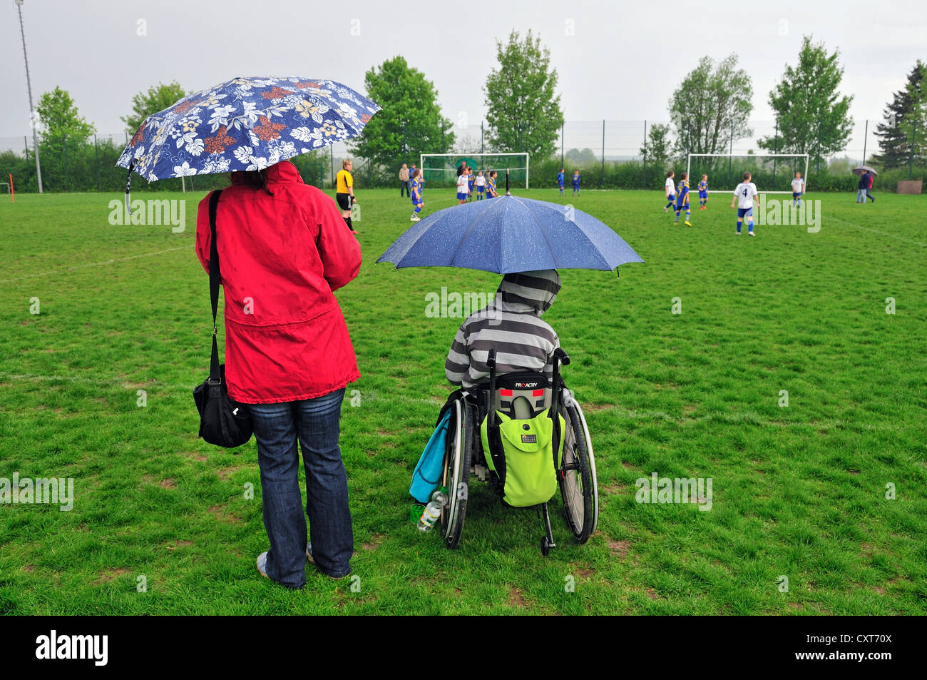 Mutter mit einem Kind im Rollstuhl gerade ein Jugend-Fußball-Spiel, Baden-Württemberg, Deutschland, Europa, PublicGround Stockfoto