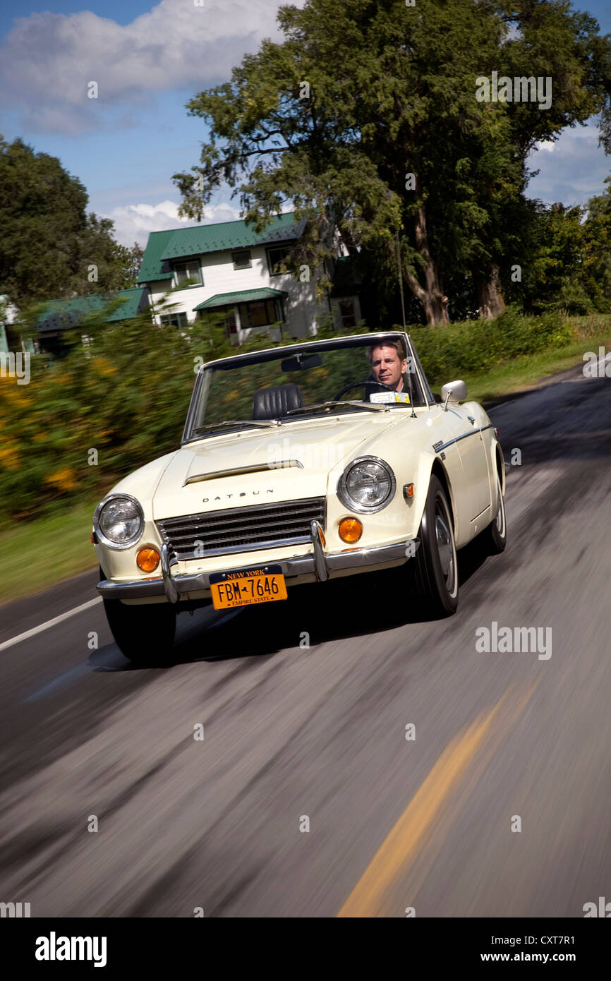 1967 Datsun 1600 Sportwagen fahren auf einer Landstraße Stockfoto