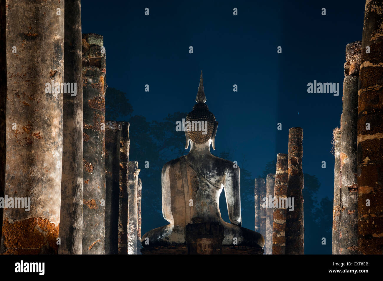 Sitzende Buddha-Statue im Tempel Wat Mahathat, nachts, Sukhothai Historical Park, UNESCO-Weltkulturerbe, Nord-Thailand Stockfoto