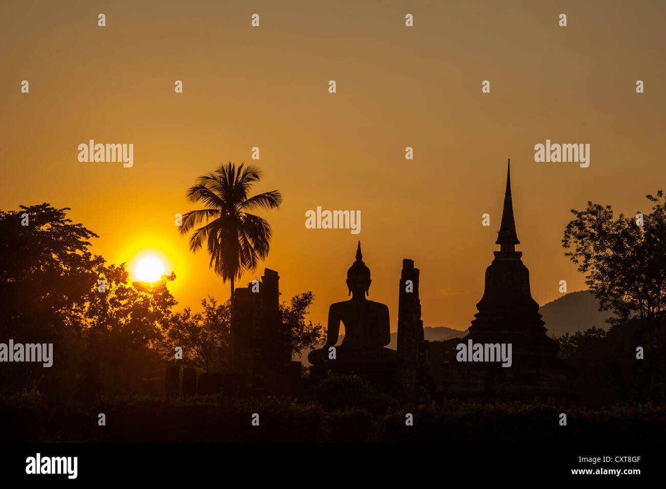 Silhouette der eine sitzende Buddha-Statue bei Sonnenuntergang, Wat Mahathat Tempel, Sukhothai Historical Park, UNESCO-Weltkulturerbe Stockfoto