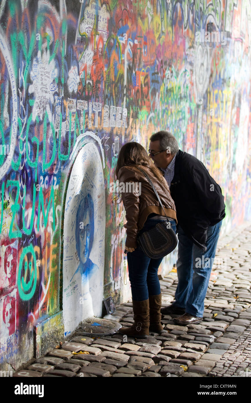 Mann und Frau liest die Graffiti an der John Lennon Wand in Prag Stockfoto