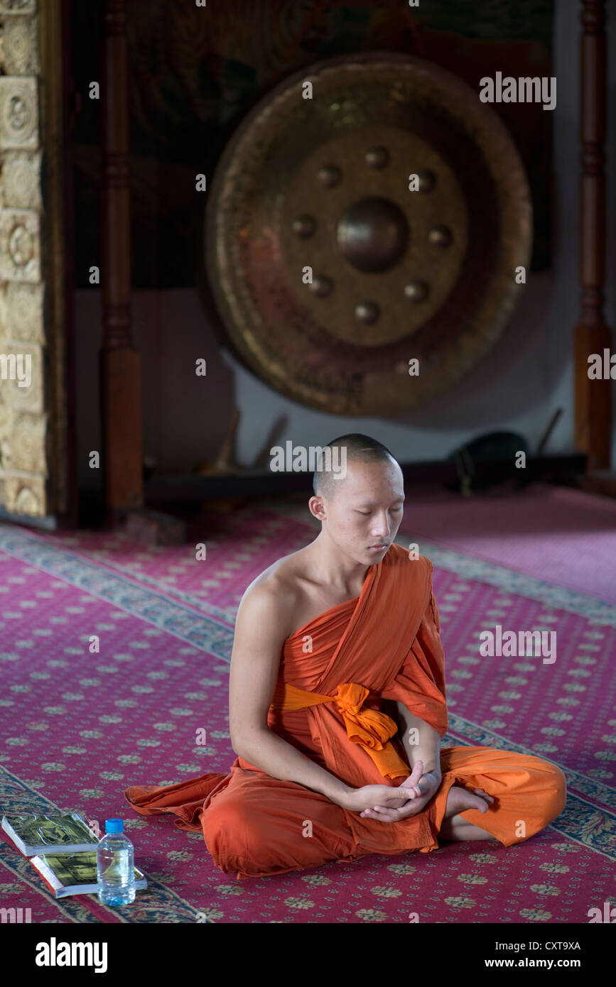 Ein buddhistischer Mönch meditiert in einem Tempel in Luang Prabang, Laos Stockfoto