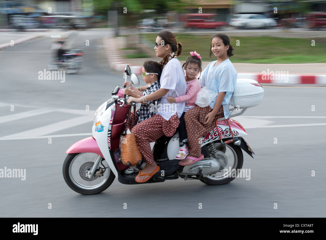 Eine junge Familie Geschwindigkeit von auf ihren Roller in der nördlichen Stadt Thailands auf Chiang Mai Stockfoto