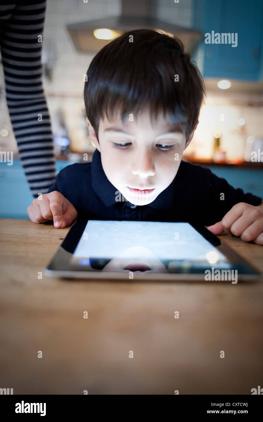 Junge starrte auf digital-Tablette auf Tisch, Nahaufnahme Stockfoto