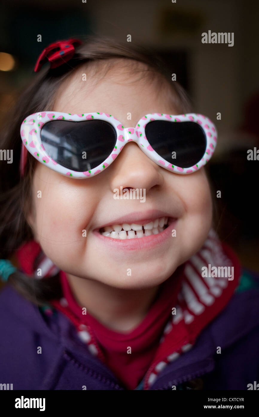 Porträt des jungen Mädchens tragen Herz geformt Sonnenbrille, Lächeln Stockfoto