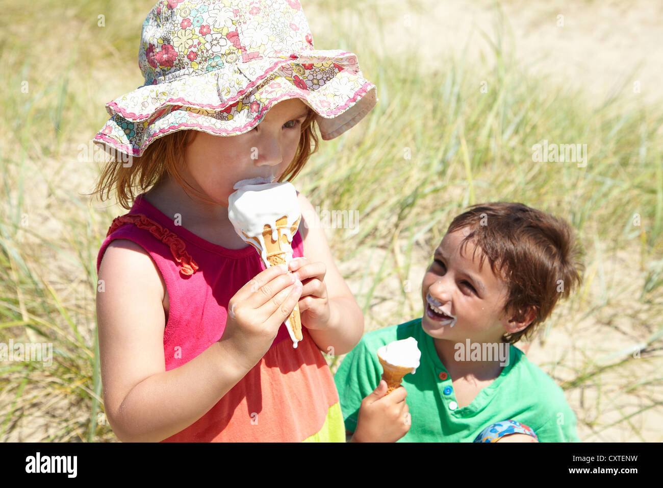 Kinder essen Eis am Strand Stockfoto