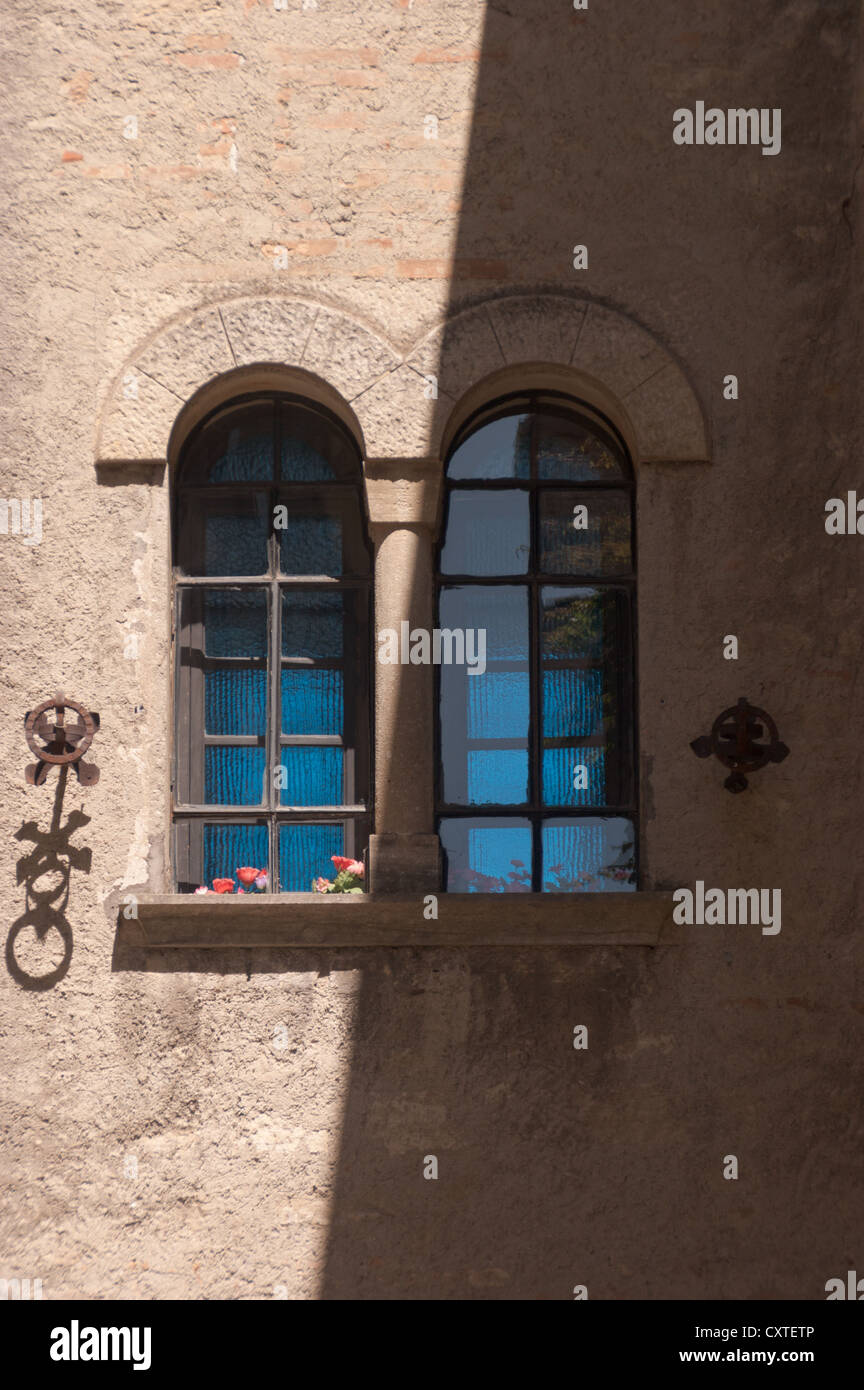 Halb schattigen zweibogigen Fenster mit zwei Lichtern auf einem alten Gebäude in der Republik San Marino Stockfoto
