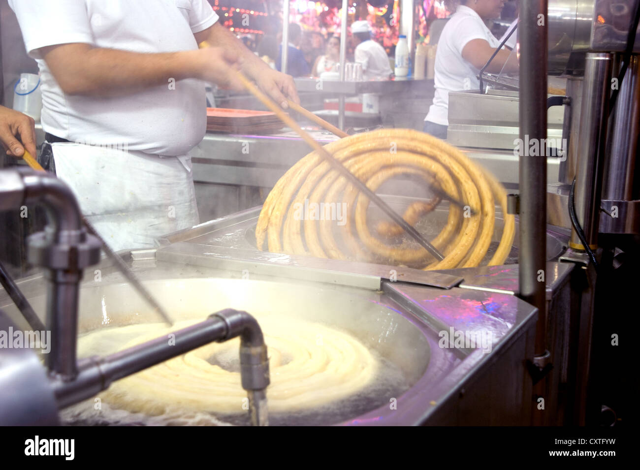 Churro Anbieter im Maria Del Mar Festival in Almeria, Spanien, Frittieren und den Verkauf der Spanische Delikatesse churros, auch als Spanische donuts bekannt. Stockfoto