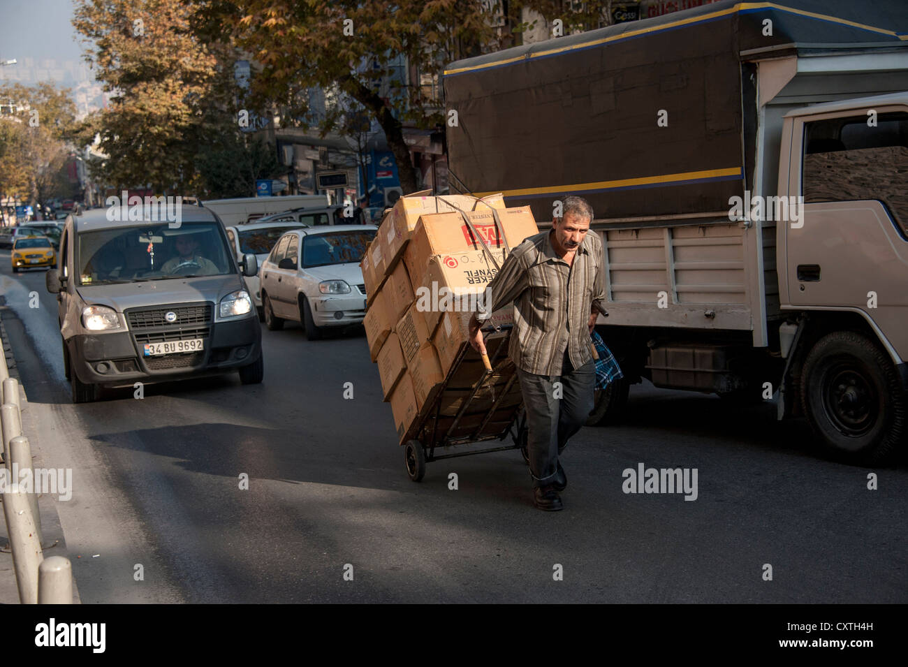 Mann mit einer Schubkarre voller Pakete in einer Straße von Istanbul Stockfoto