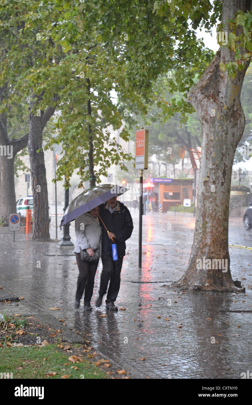 Paar mit Schirm im Regen, Sirmione, Gardasee, Provinz Brescia, Lombardei, Italien Stockfoto