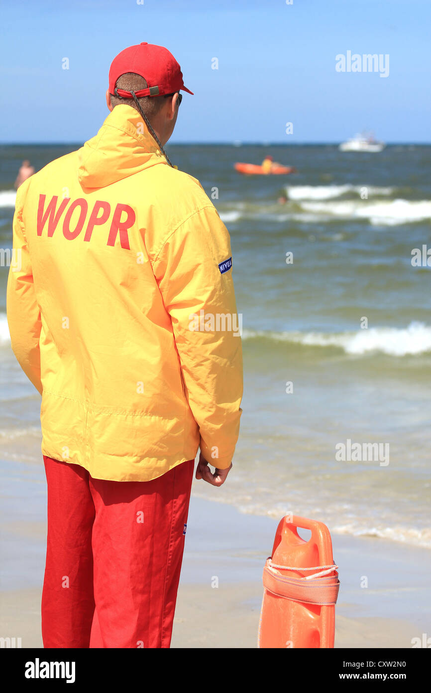 Junger Mann Lebensretter beobachten die Situation auf dem Meer. Leba, Polen Stockfoto