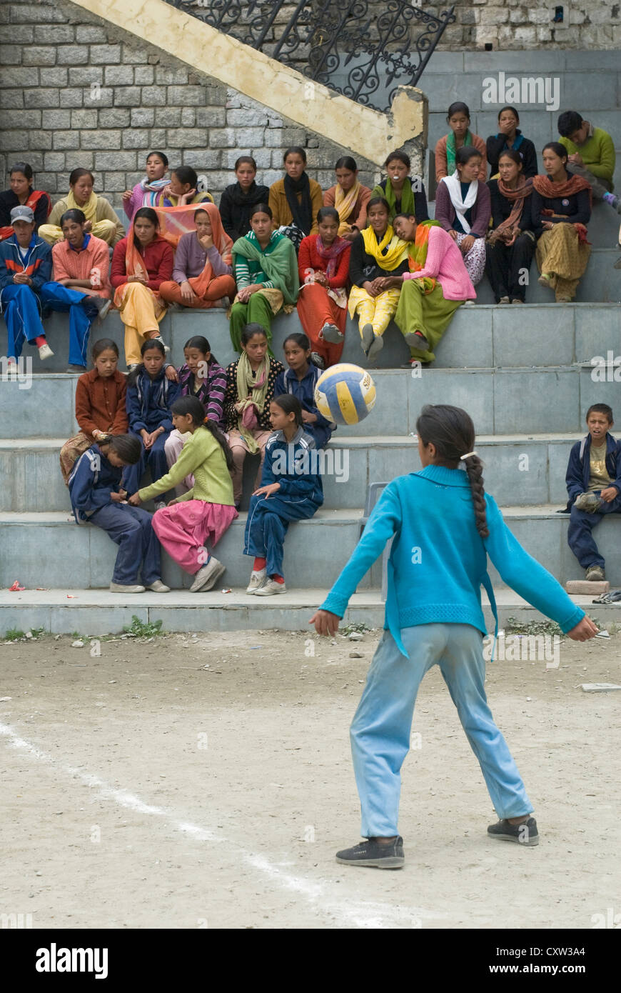 Eine Mädchen dient den Ball in ein Mädchen Volleyball Spiel in Keylong, Nord-Indien Stockfoto